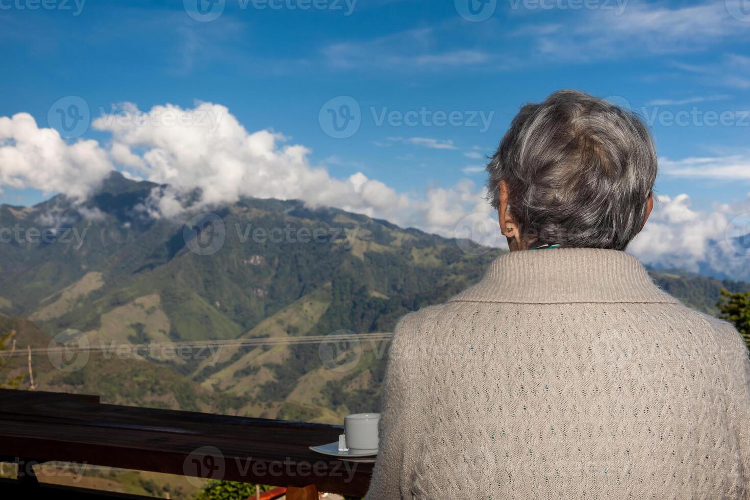 Senior woman tourist looking at the amazing landscapes of the Central Ranges on the ascent to the High of Letters between the cities of Fresno and Manizales in Colombia photo