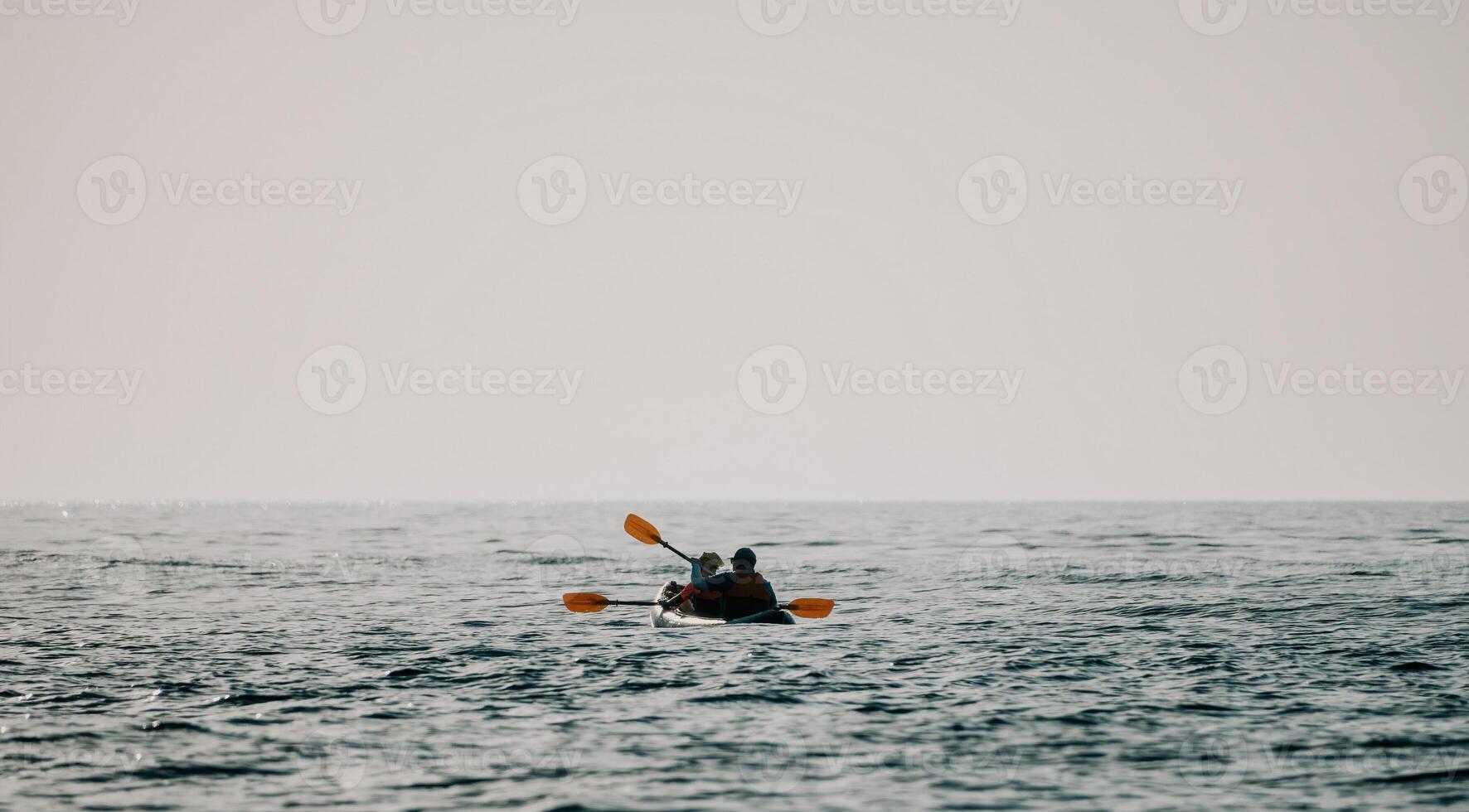 contento Pareja kayaks en un inflable kayac en el mar a puesta de sol. Pareja piragüismo en el mar cerca el isla con montañas. personas kayak en vida chaquetas navegar. espalda ver foto