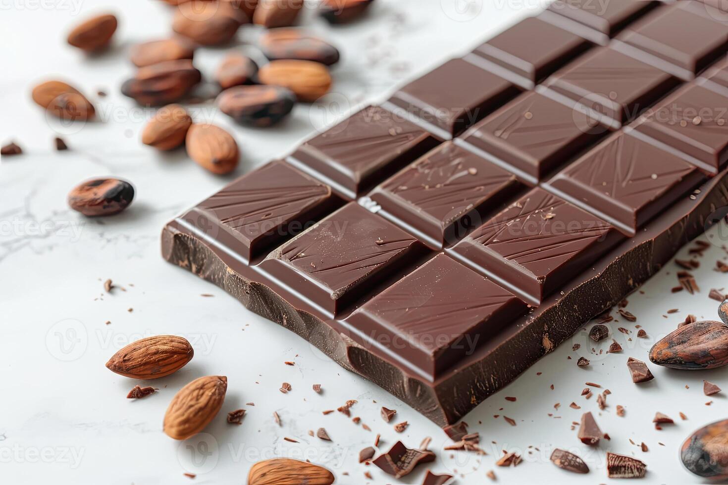 Chocolate bar with cacao beans and almonds scattered around it photo