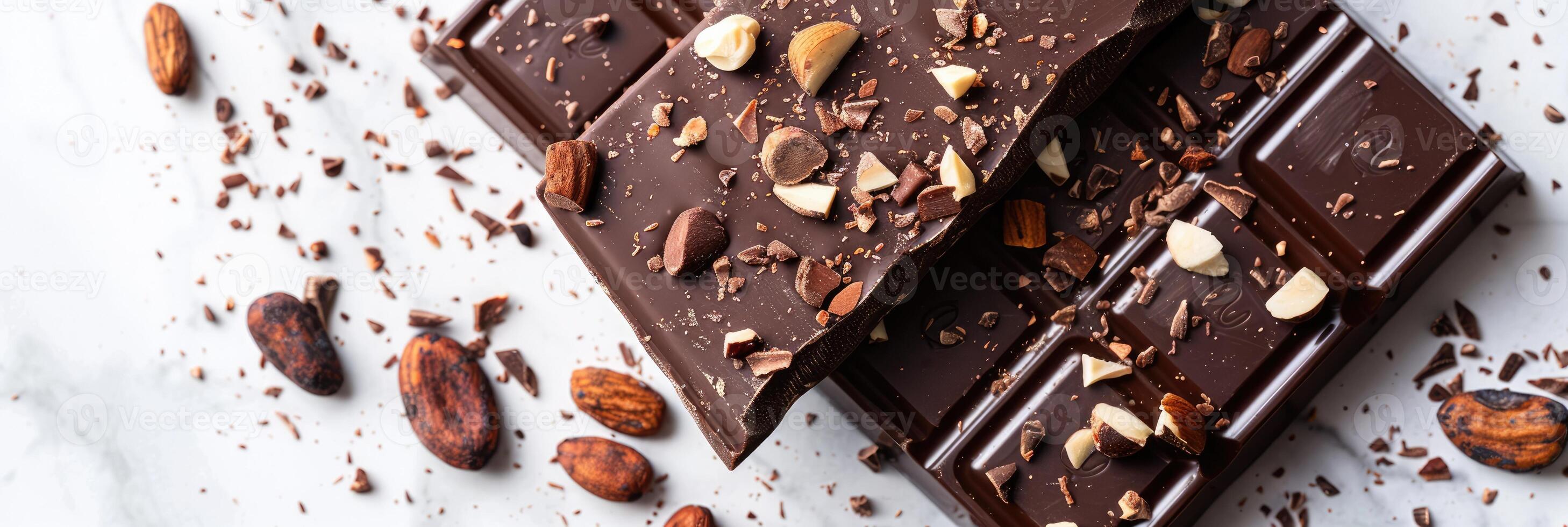 Chocolate bar with cacao beans and almonds scattered around it photo