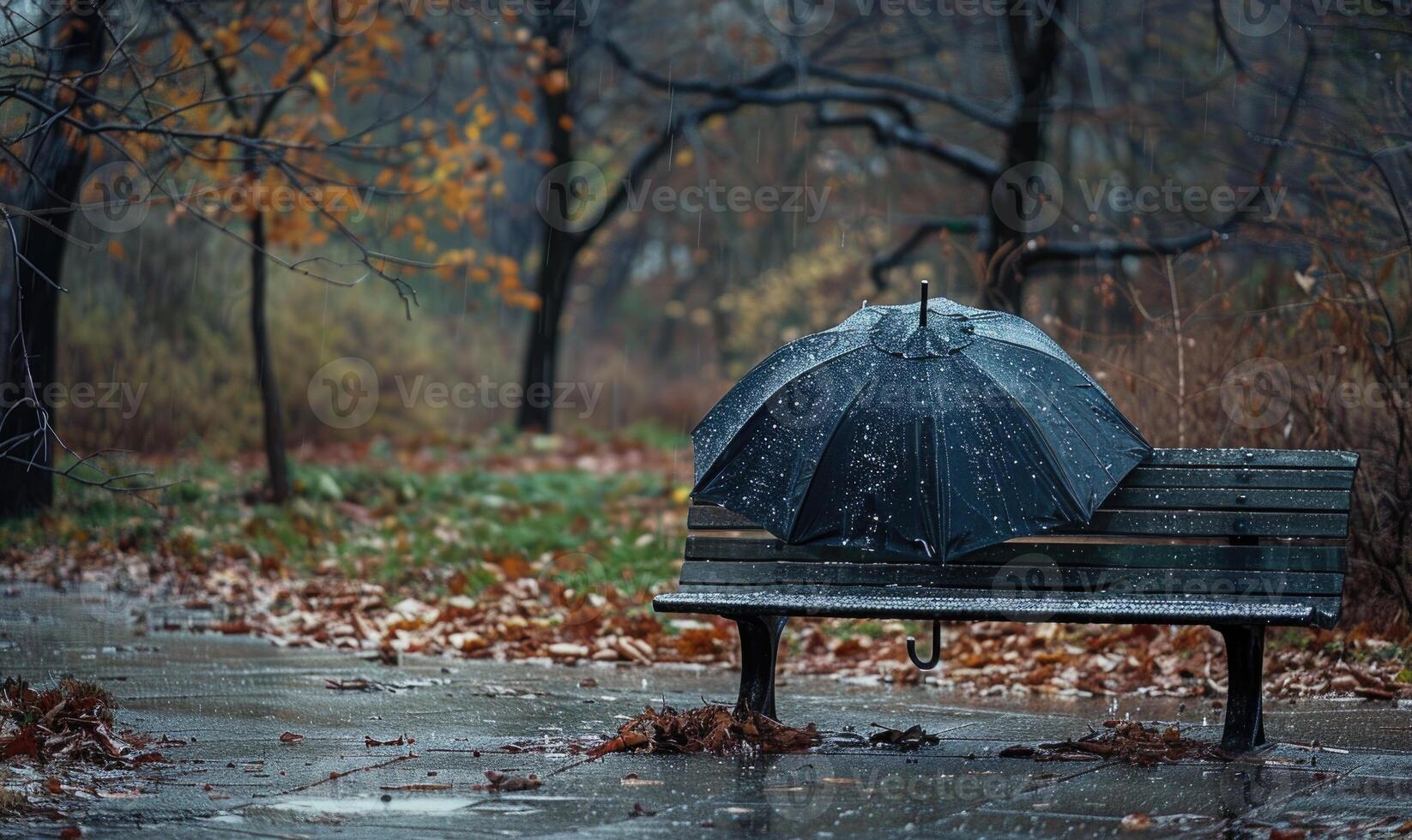 A lone umbrella on a wet park bench during in the rain photo