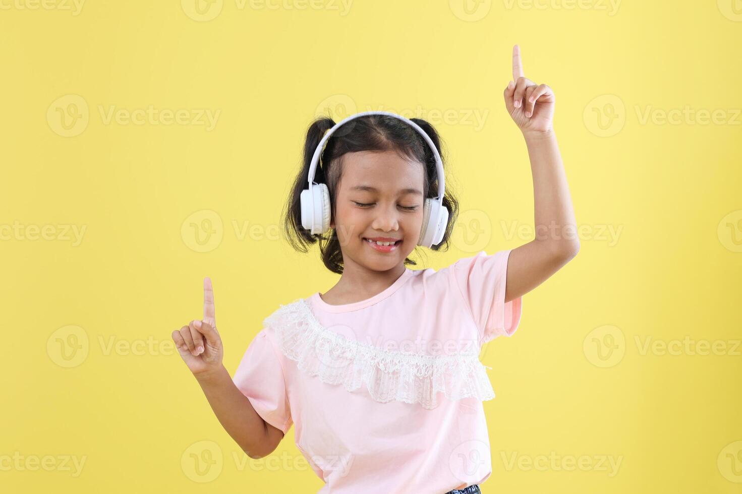 linda asiático niños escuchando a música utilizando inalámbrico auriculares foto