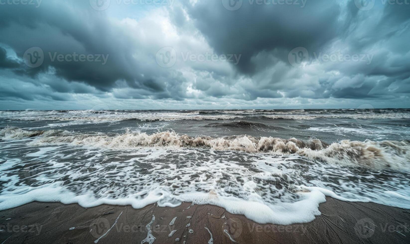 A rainy day at the beach, waves crashing against the shore and rain clouds looming overhead photo