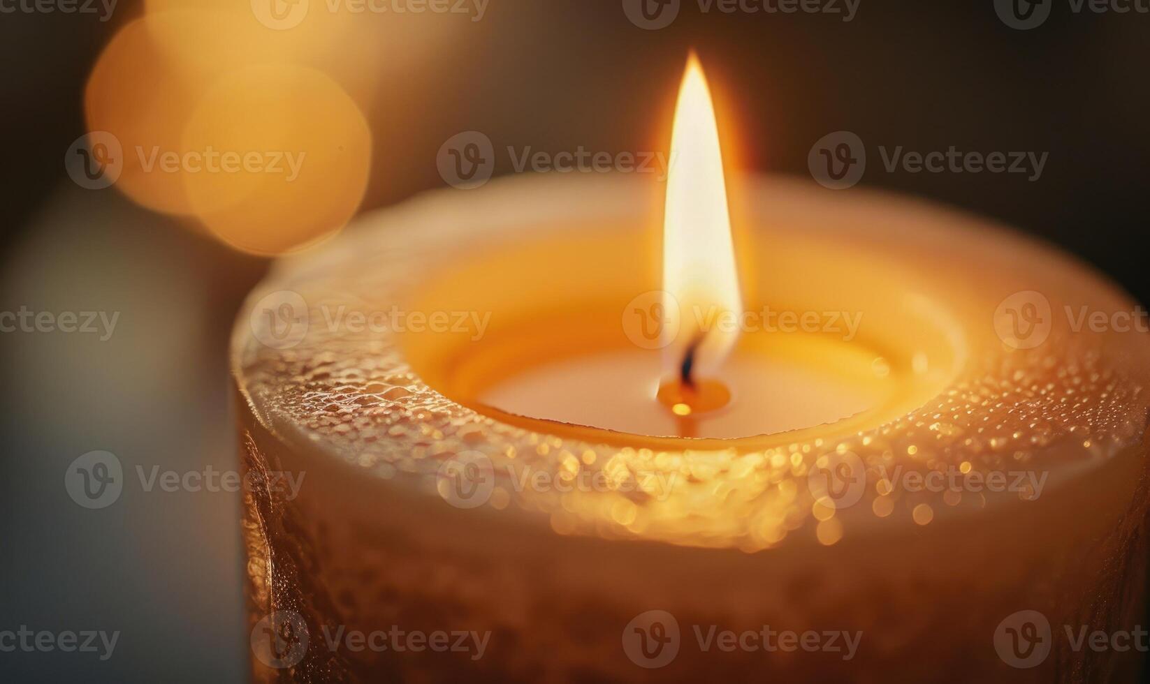 Close-up of a flickering candle flame casting a warm glow photo