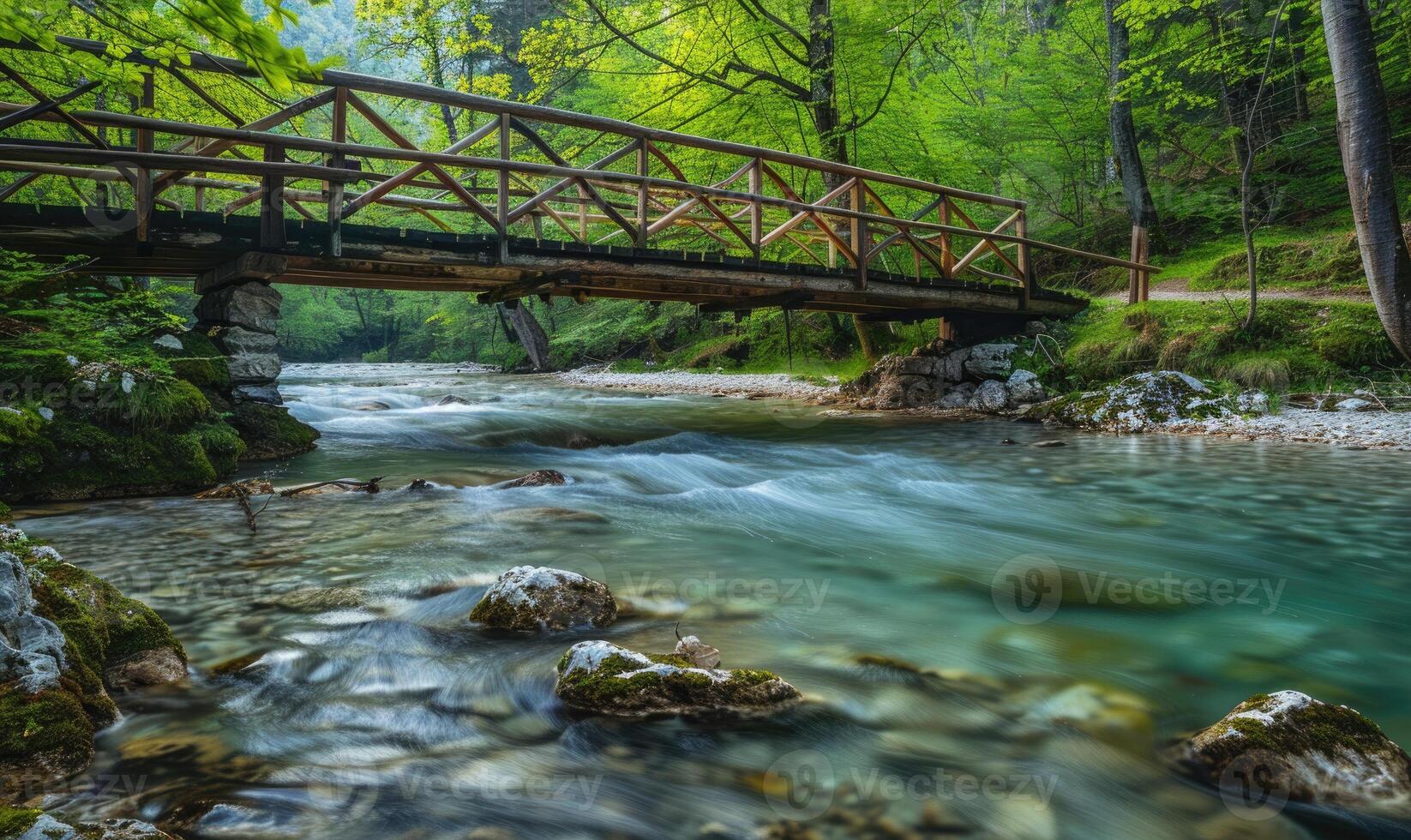 A rustic wooden bridge spanning over a crystal-clear spring river photo