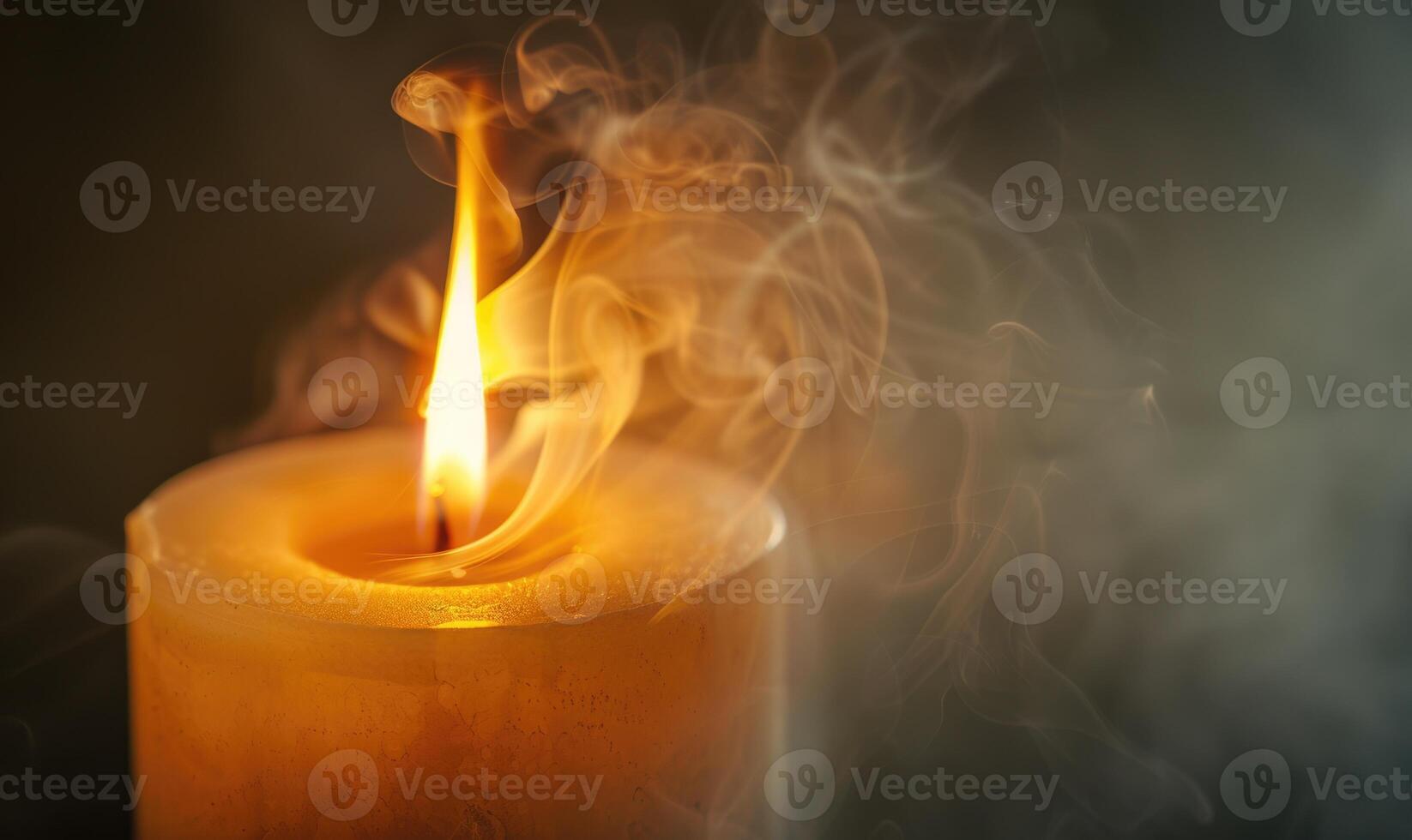 Close-up of a candle with wisps of smoke rising from the flame photo