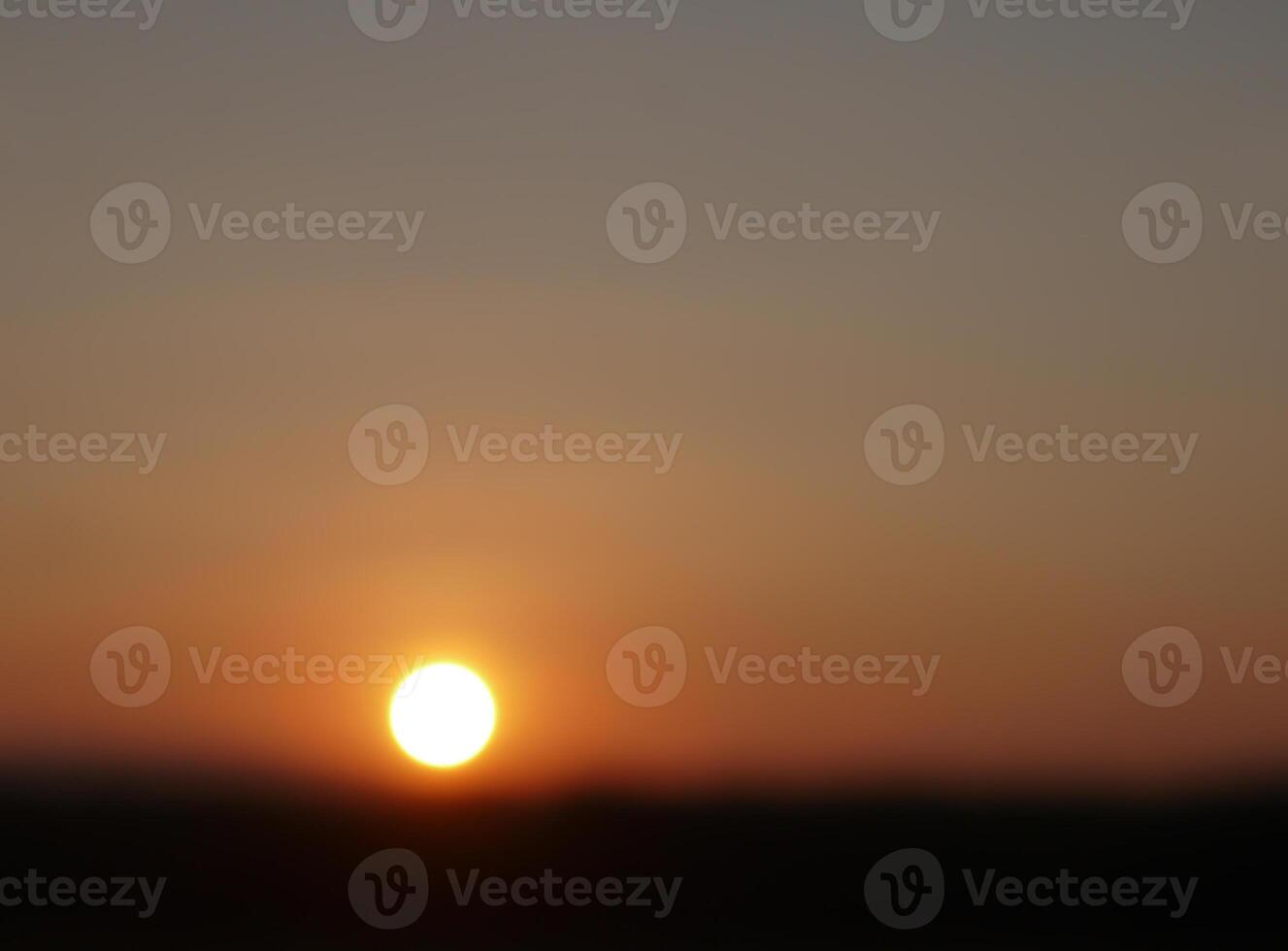 Spectacular sunset over, orange sun rising up over the horizon photo