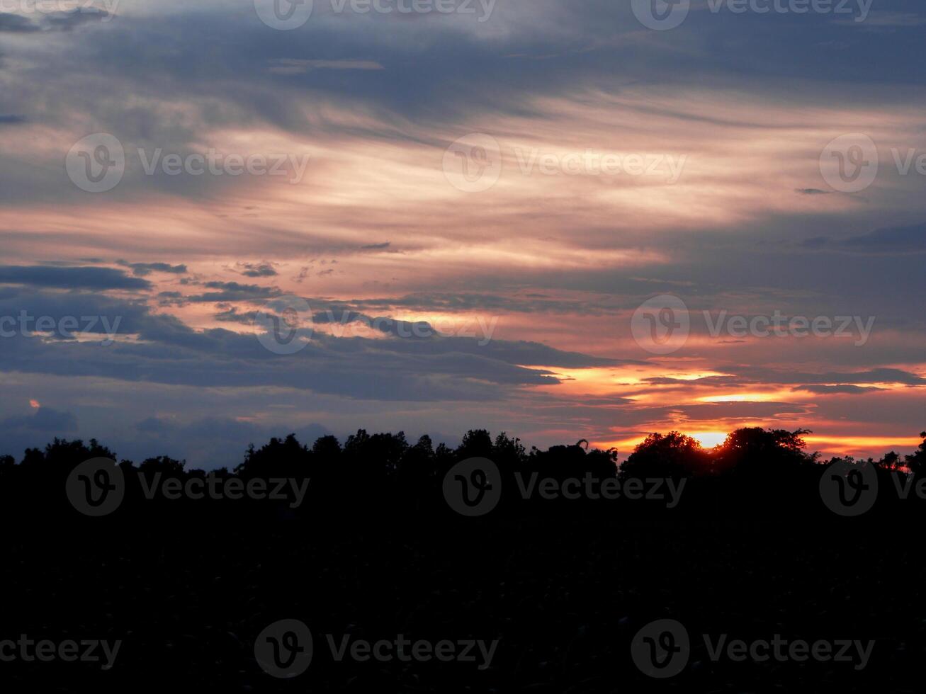 Spectacular sunset over, orange sun rising up over the horizon photo