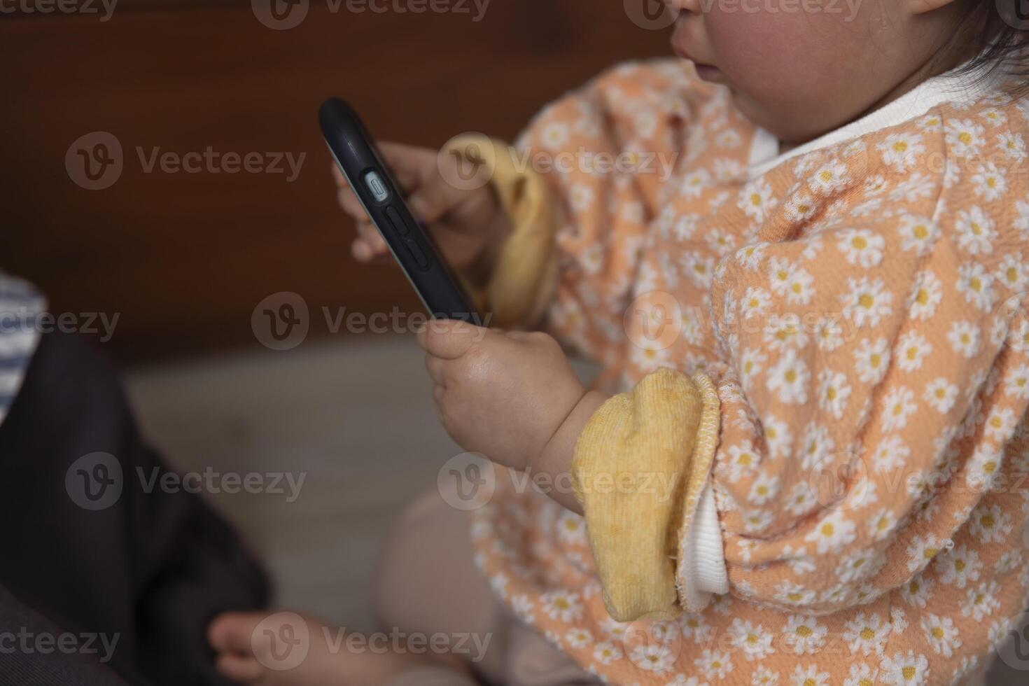 Child's hands with smartphone in the living room closeup photo
