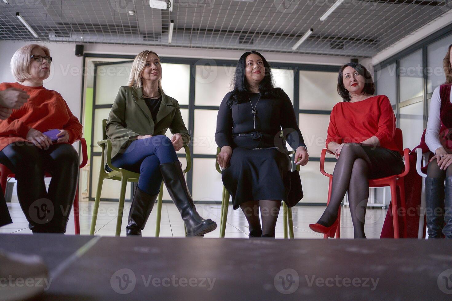 office workers listen to their colleagues on stage, view from the stage floor photo