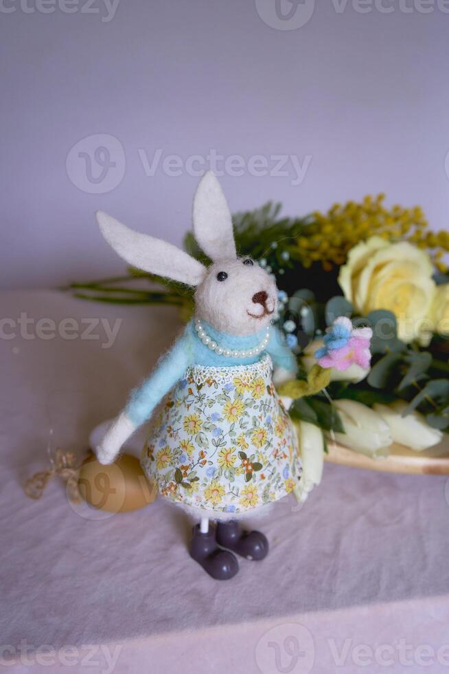 flowers and a rabbit lie on a wooden stand of a florist on a table until they are made into a flower arrangement for Easter photo