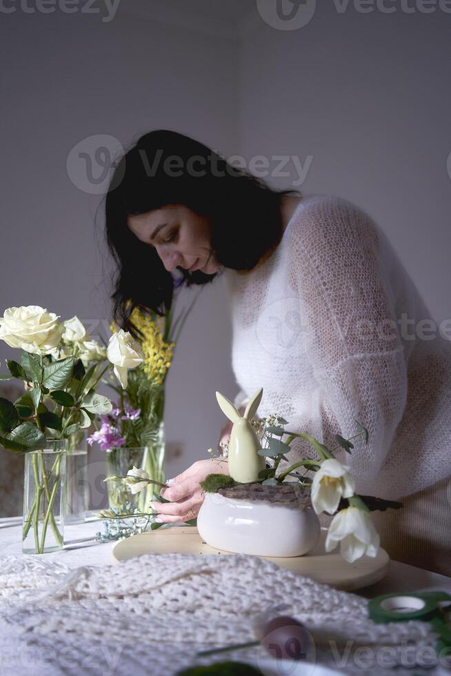 hembra florista hacer decoraciones y floral preparativos para Pascua de Resurrección foto