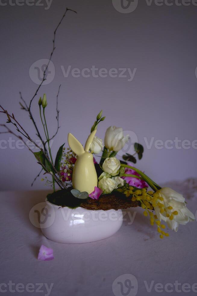 Easter flower arrangement with a ceramic rabbit in a minimalist style photo