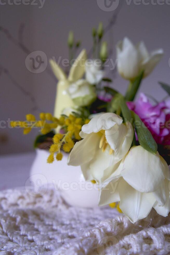 Easter flower arrangement with a ceramic rabbit in a minimalist style photo