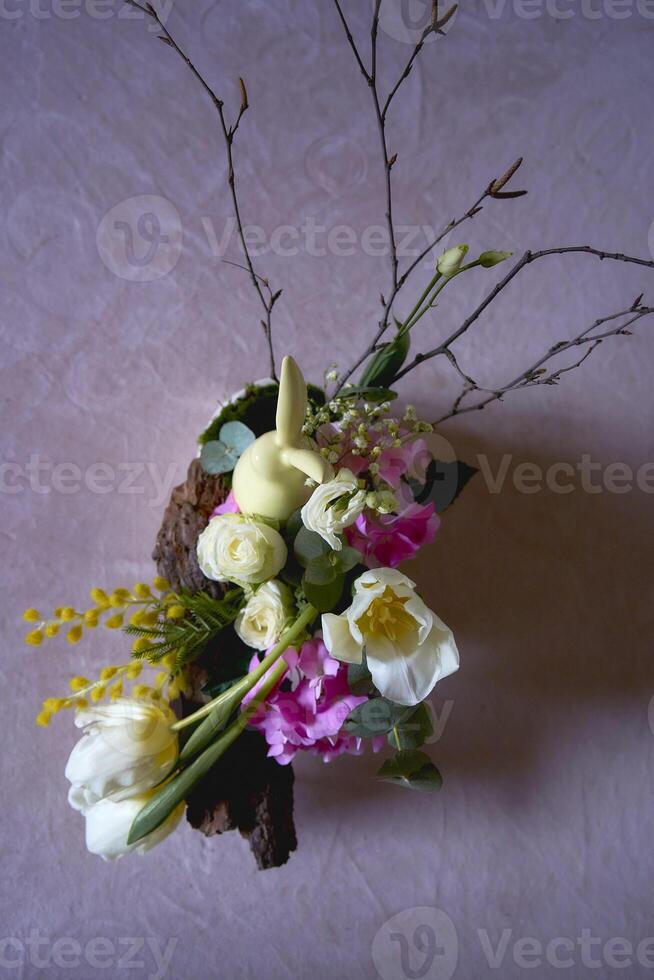 Easter flower arrangement with a ceramic rabbit in a minimalist style photo