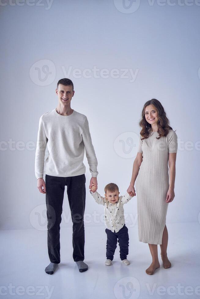 a minimalist portrait of a mother, father and their two-year-old son on a white background photo