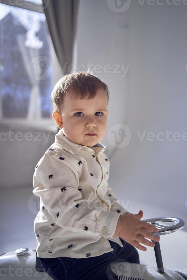 A toddler is enthusiastically playing with his toy car on his birthday photo