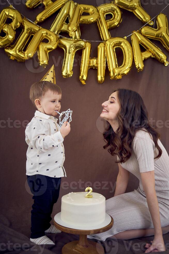 muy emocional mamá y su pequeño cumpleaños chico comiendo pastel foto
