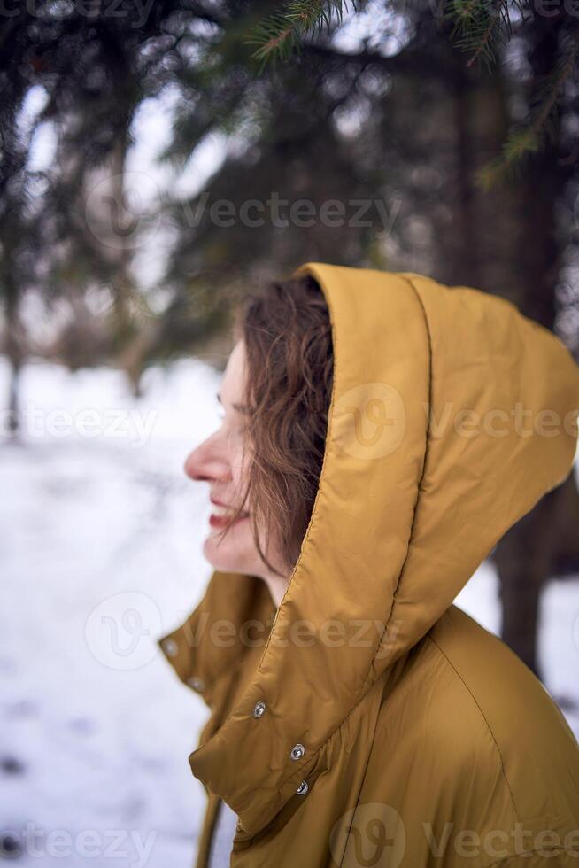 woman in yellow coat in the forest photo