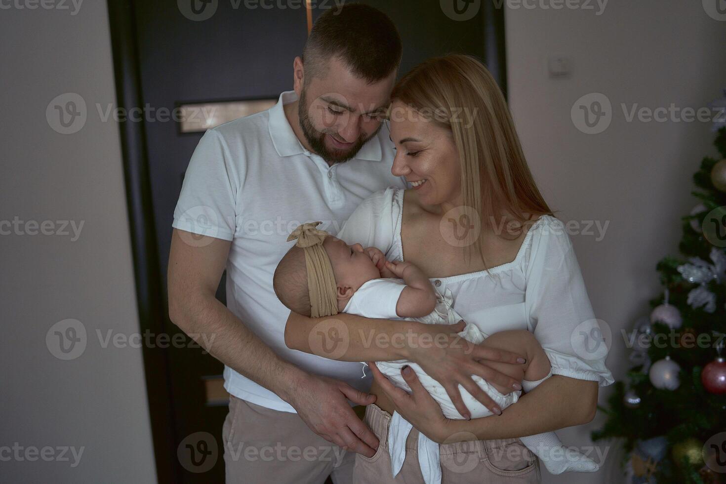 Parents hold a baby at home photo