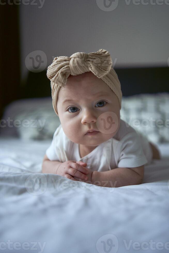 four months old baby lay on the bed photo