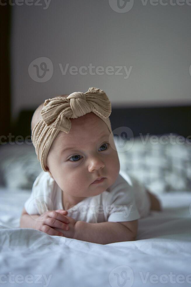 four months old baby lay on the bed photo