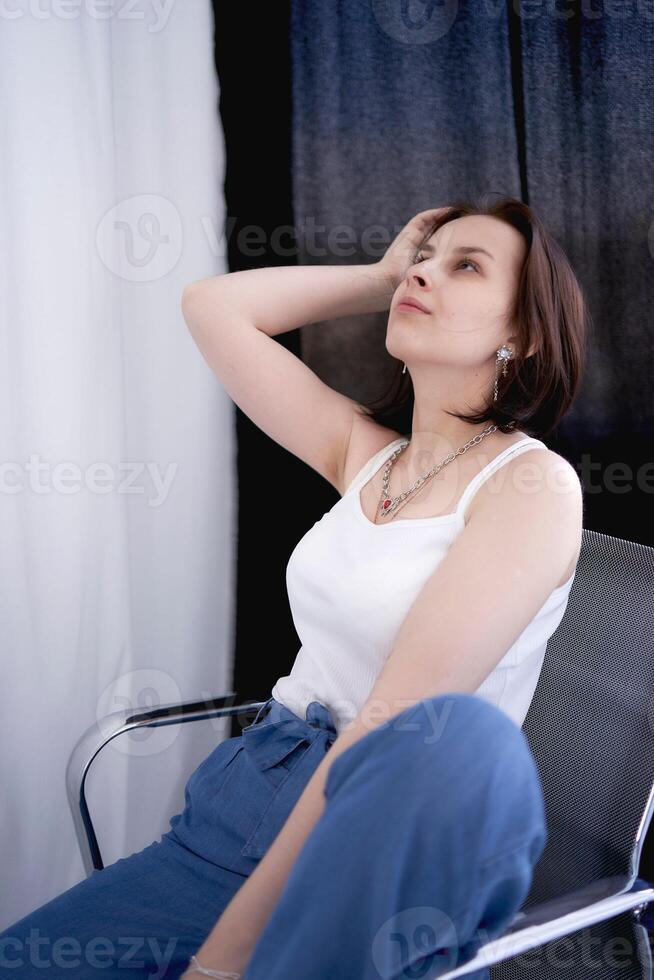 young teenage girl fighting brain cancer at photo shoot in studio sitting on chair between white curtains