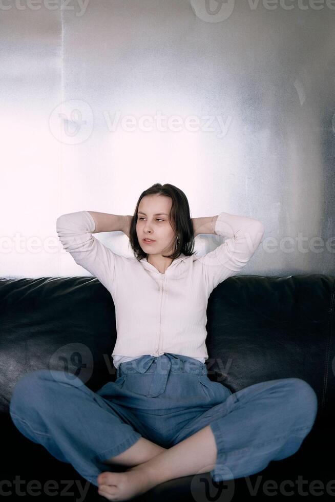 joven Adolescente niña luchando cerebro cáncer a foto disparar en estudio, metal muro, reflexión, negro sofá