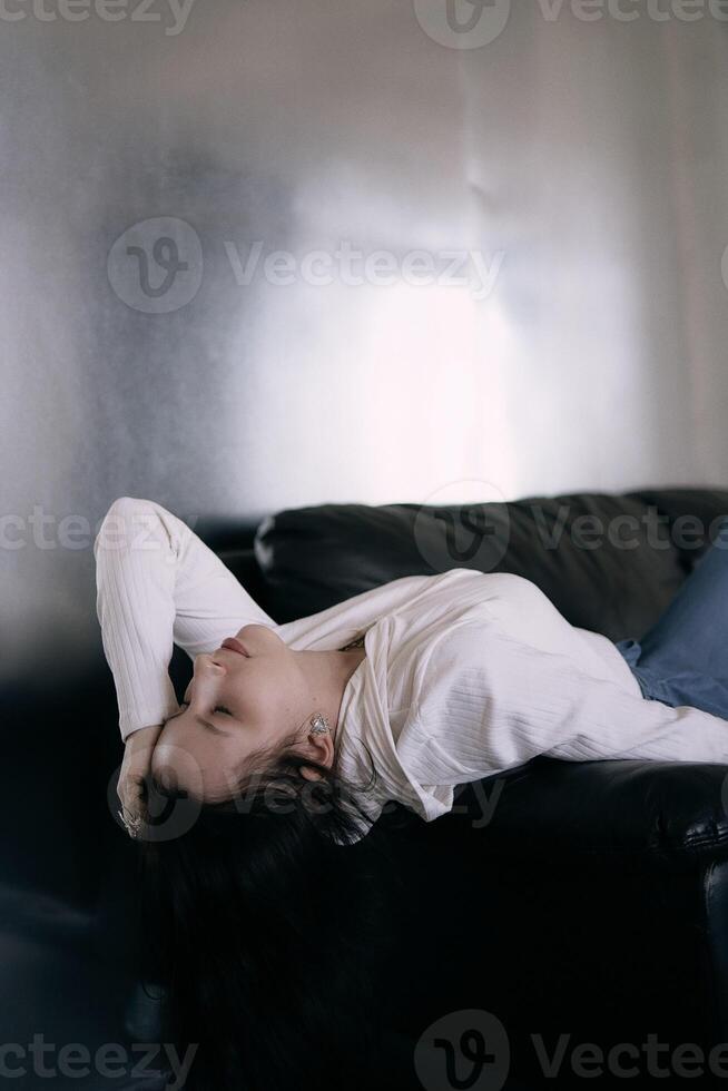 young teenage girl fighting brain cancer at photo shoot in studio, metal wall, reflection, black sofa