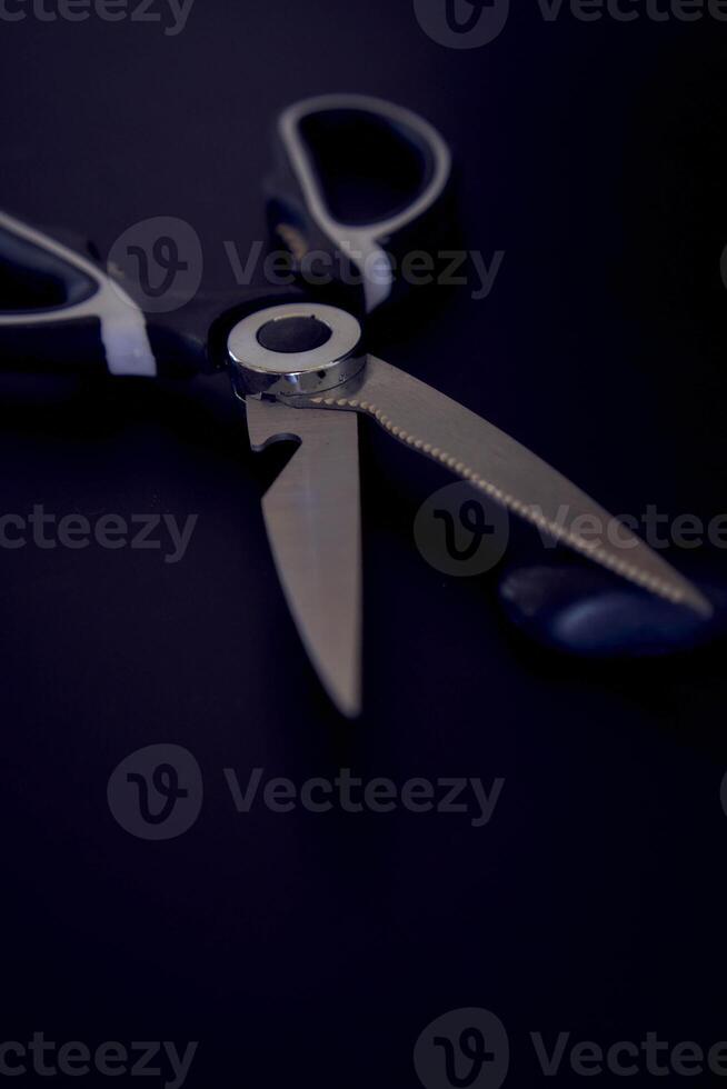 kitchen scissors with a jagged blade on a black background photo