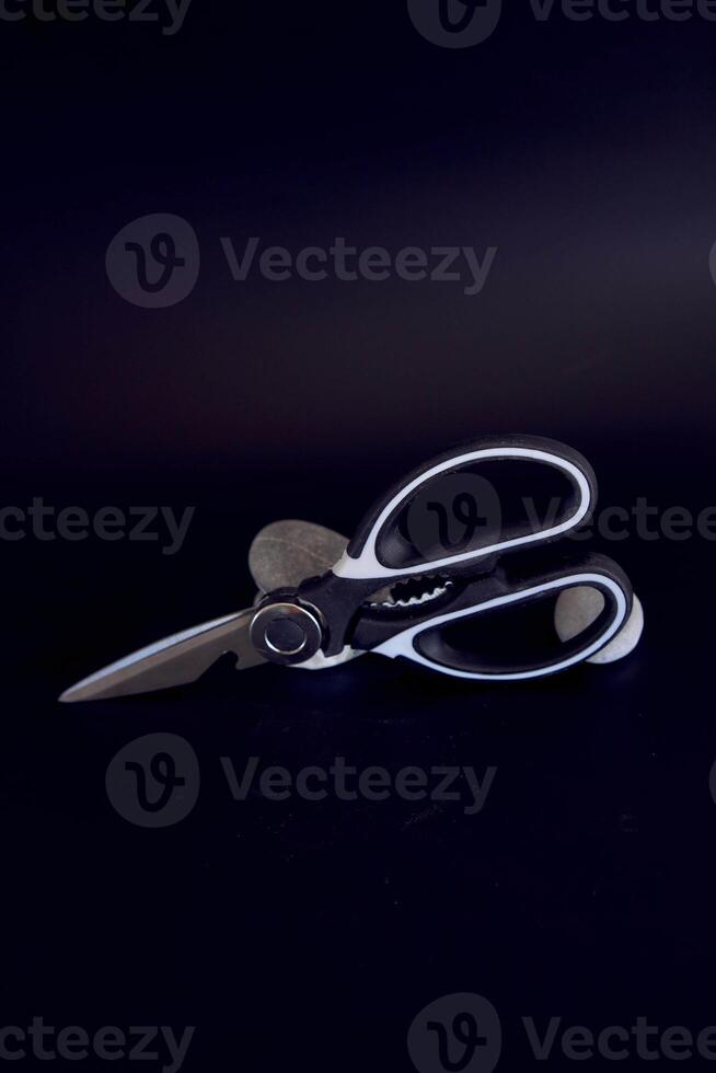 kitchen scissors with a jagged blade on a black background photo