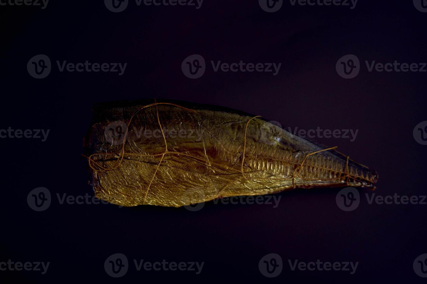 appetizing hot smoked golden horse mackerel on a black background photo