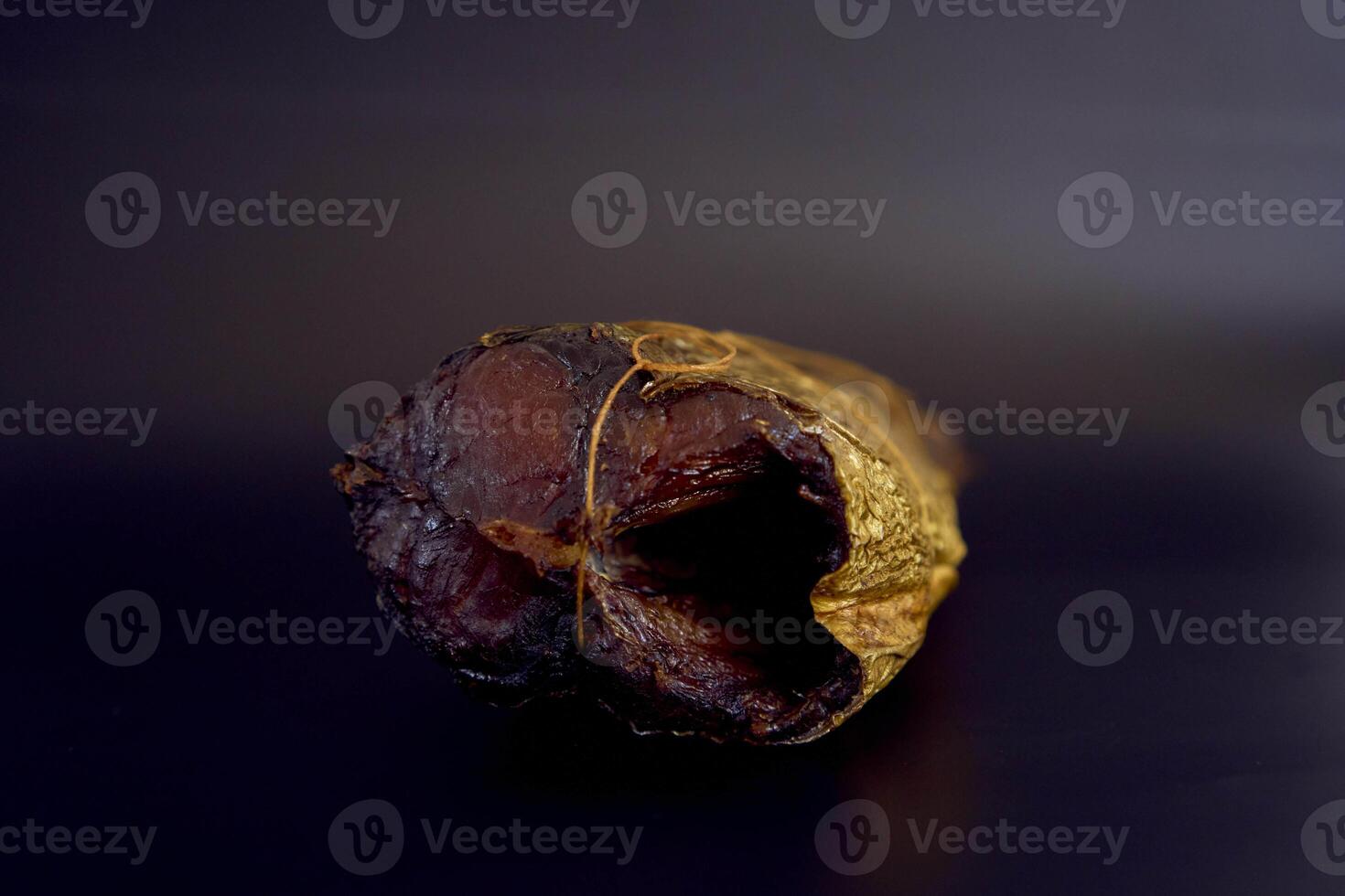 appetizing hot smoked golden horse mackerel on a black background photo