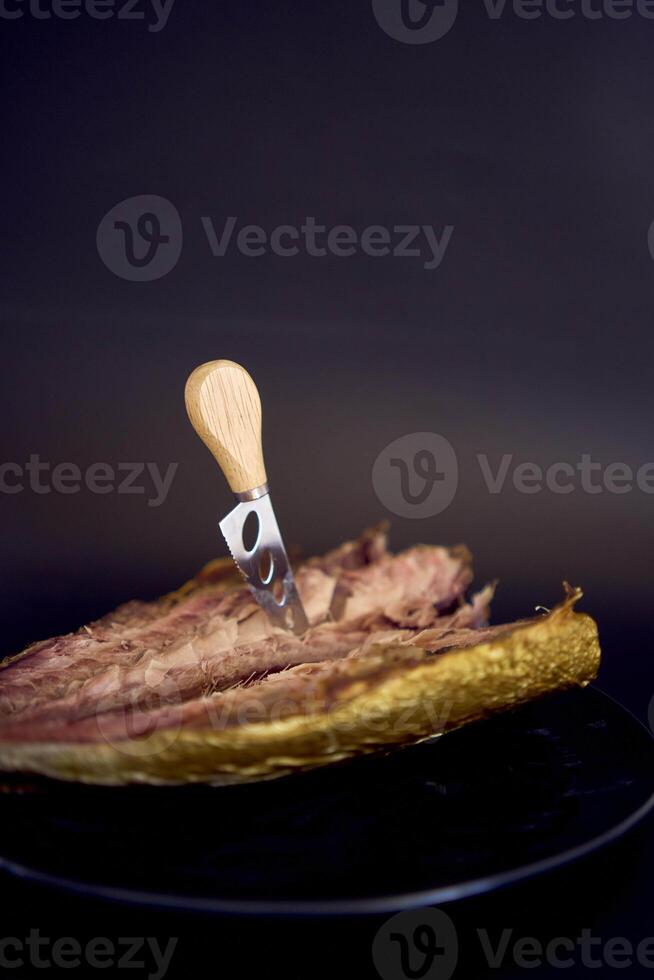 the  process of dissecting hot smoked golden horse mackerel with small knives photo