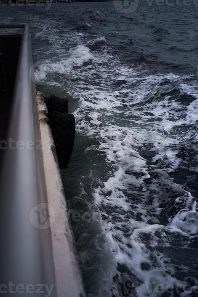 waves splash over the side of the ship, foam photo