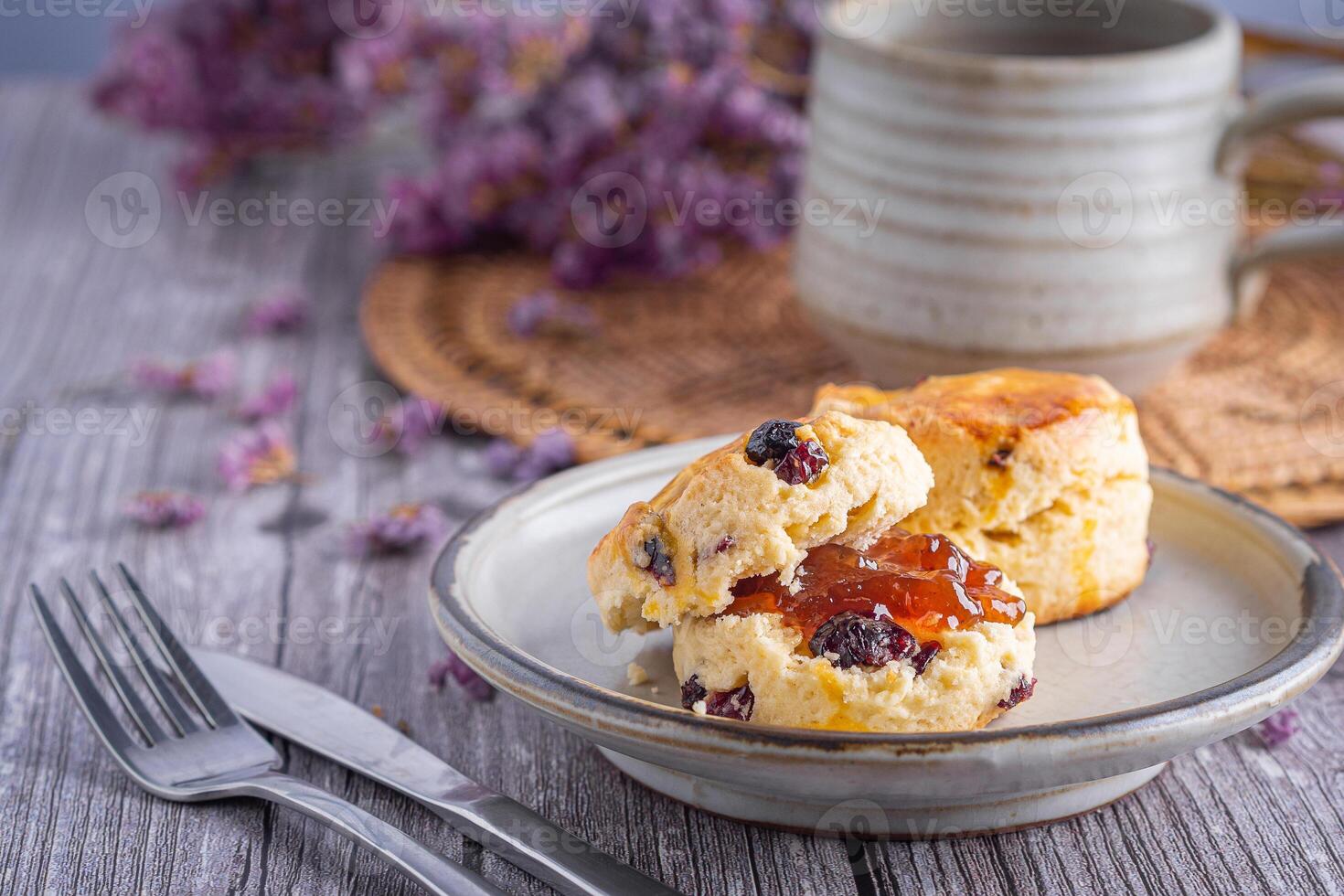 Close-up of traditional British scones on a plate and a tea hot cup with blurred background. Space for text photo