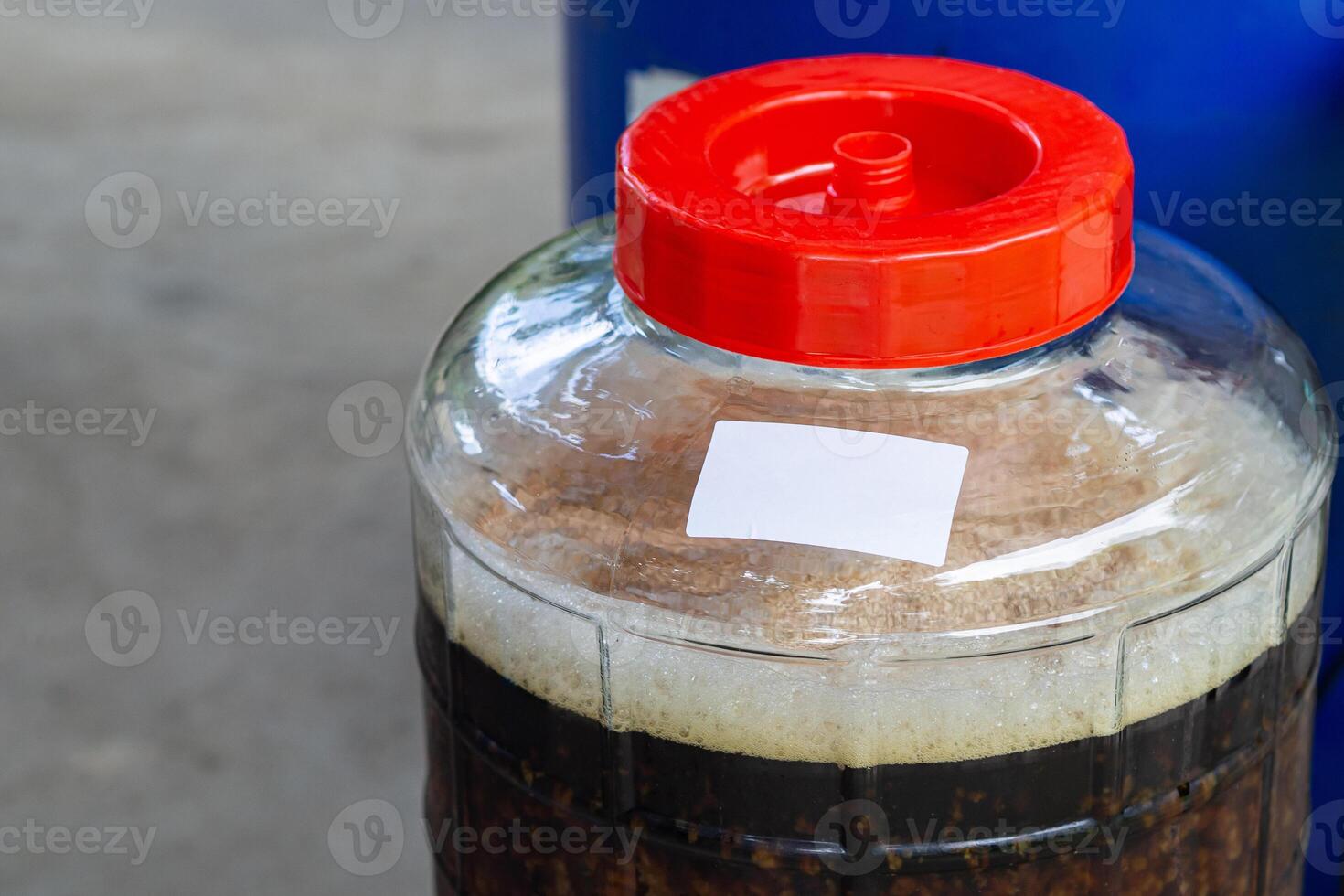 Close-up of craft beer and foam in a fermentation container. Process of making home beer from malt. Craft beer from barley and dark malt photo