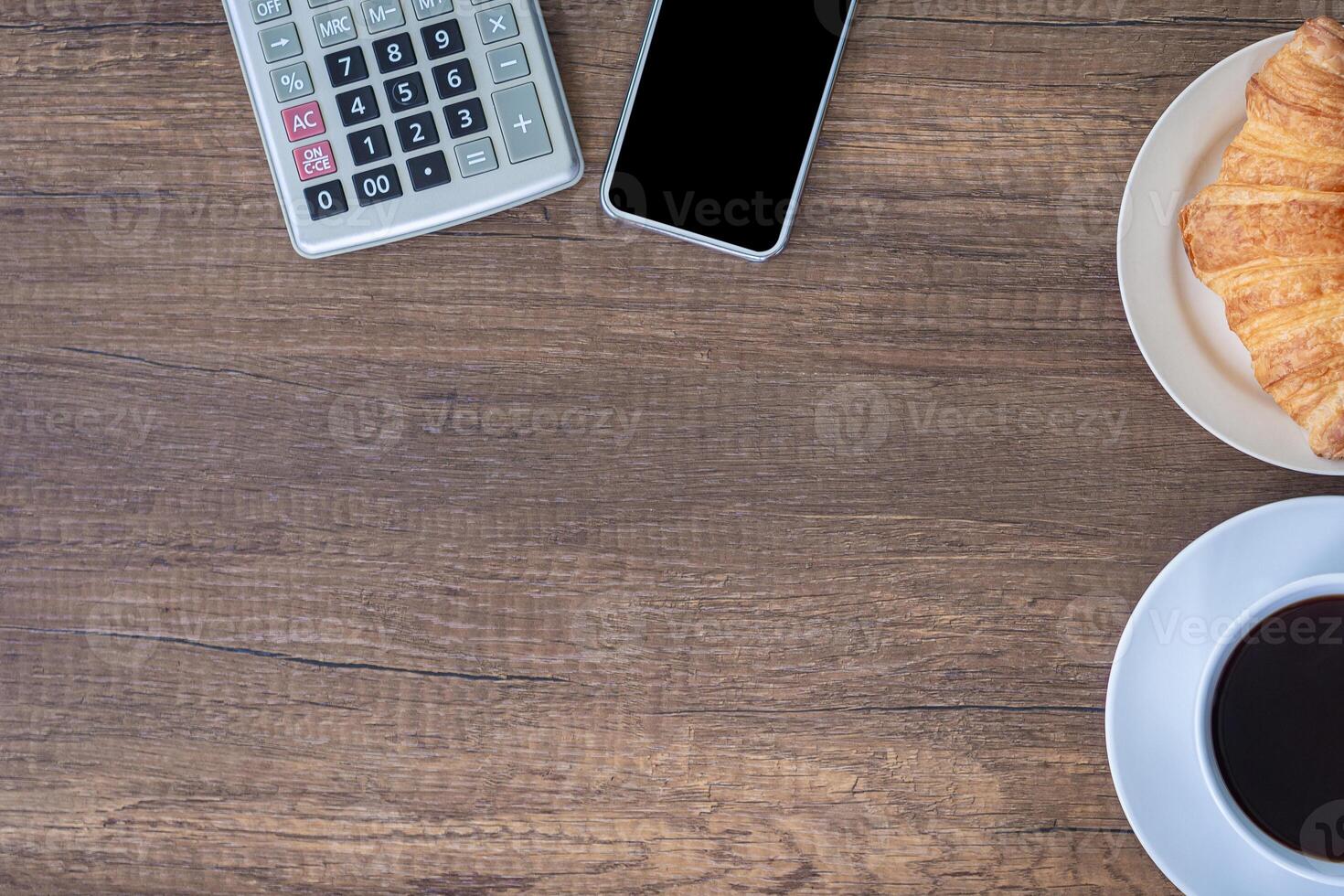 Top view of a tablet, calculator, and smartphone on a wooden table. Space for text photo