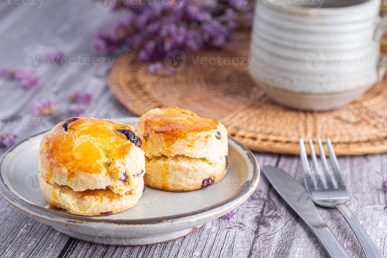 Close-up of traditional British scones on a plate with a cup of tea and flower blurred background. Space for text photo