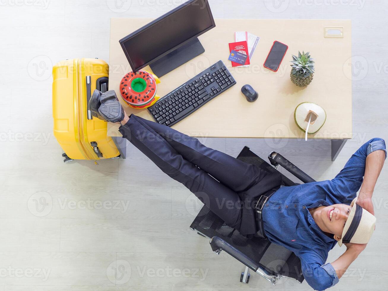 Young man wearing a hat very happy, close eyes, placing both hands on the back of the neck and foot on the table for relaxing while sitting on a chair. Holiday coming soon. Holiday concept photo