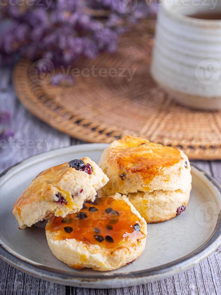 Close-up of traditional British scones on a plate with a tea cup and flower blurred background. Space for text photo