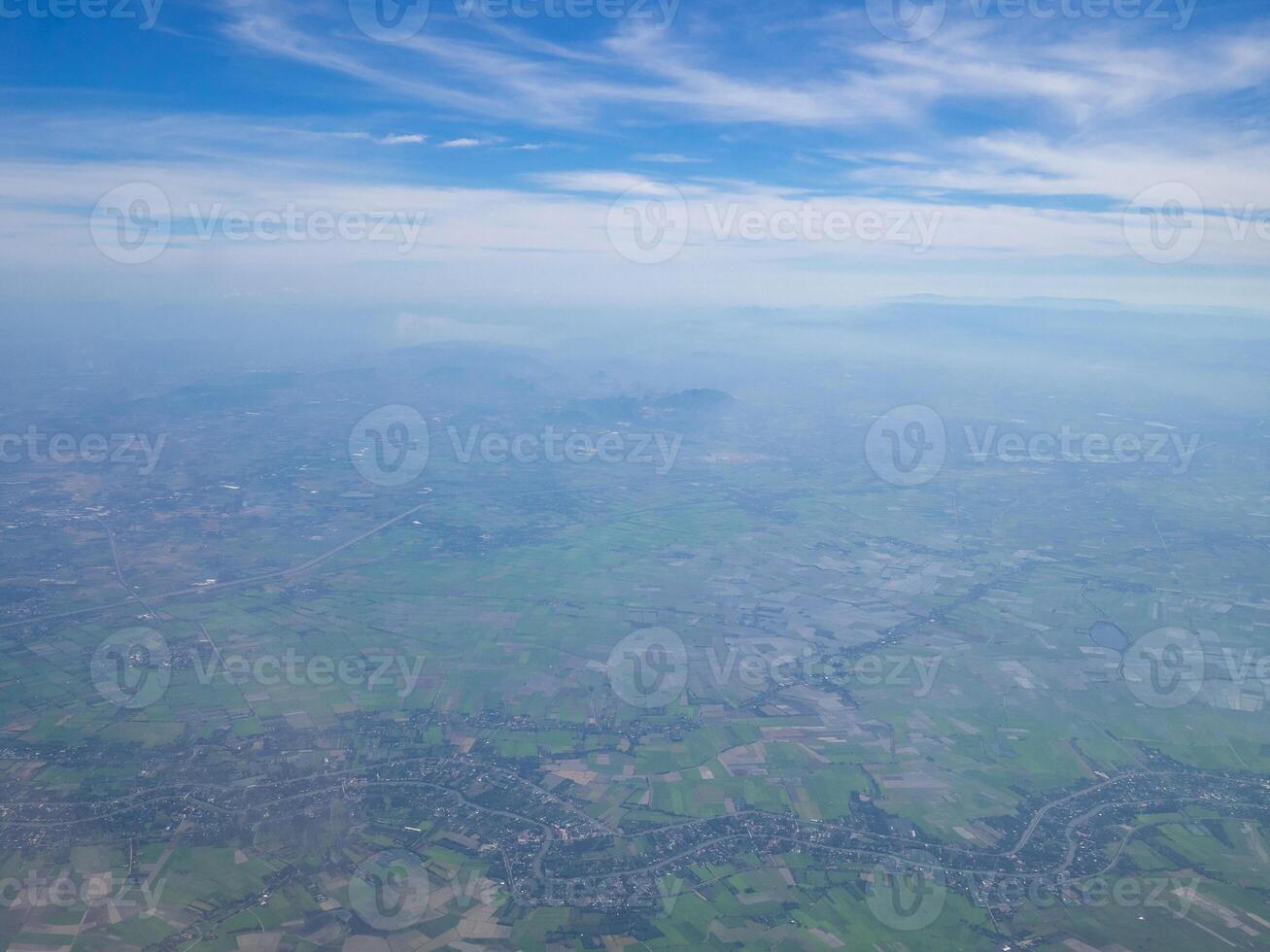 Aerial view of lands and clouds seen through the airplane window photo