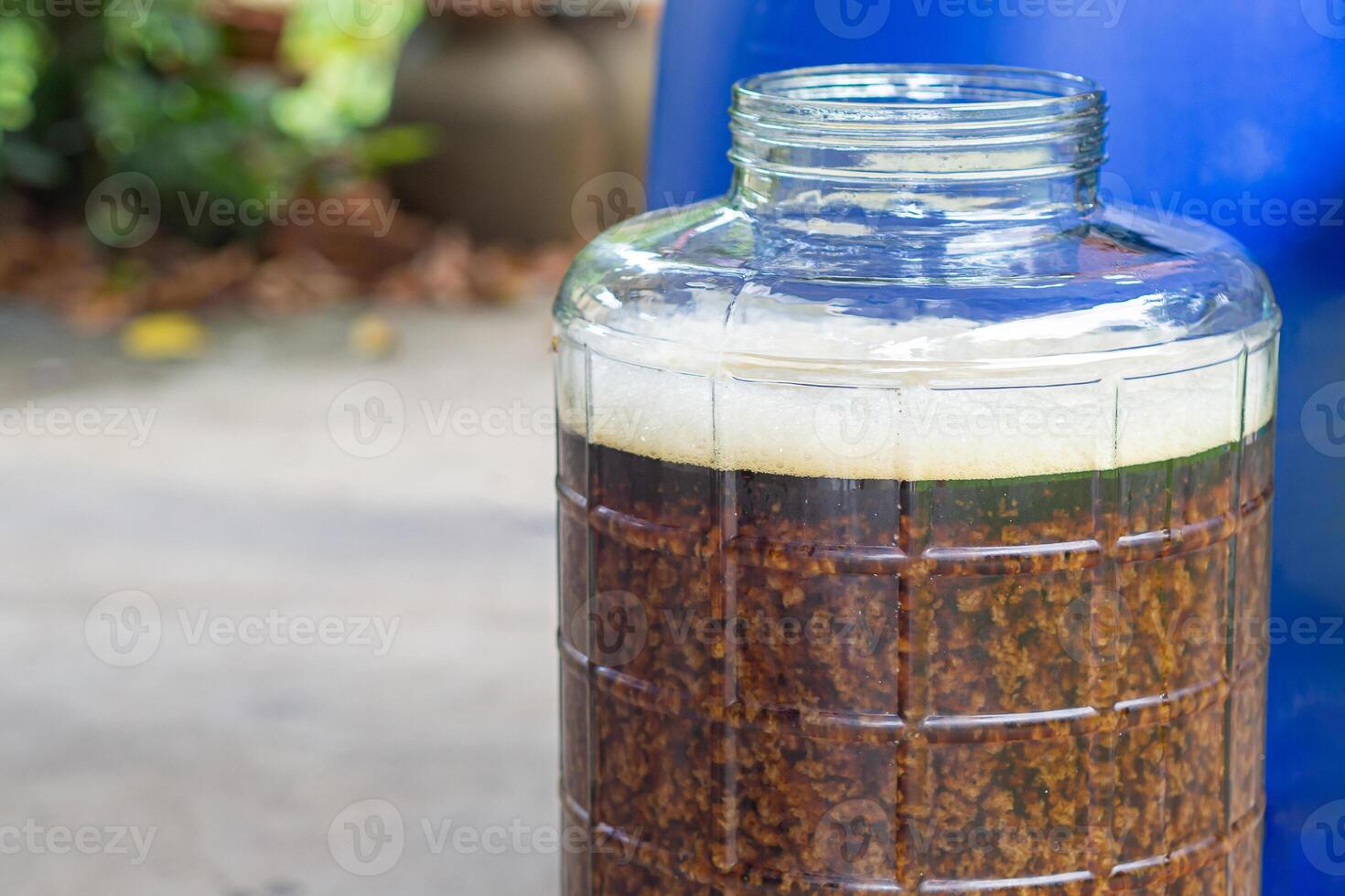 Close-up of craft beer and foam in a fermentation container. Process of making home beer from malt. Craft beer from barley and dark malt photo