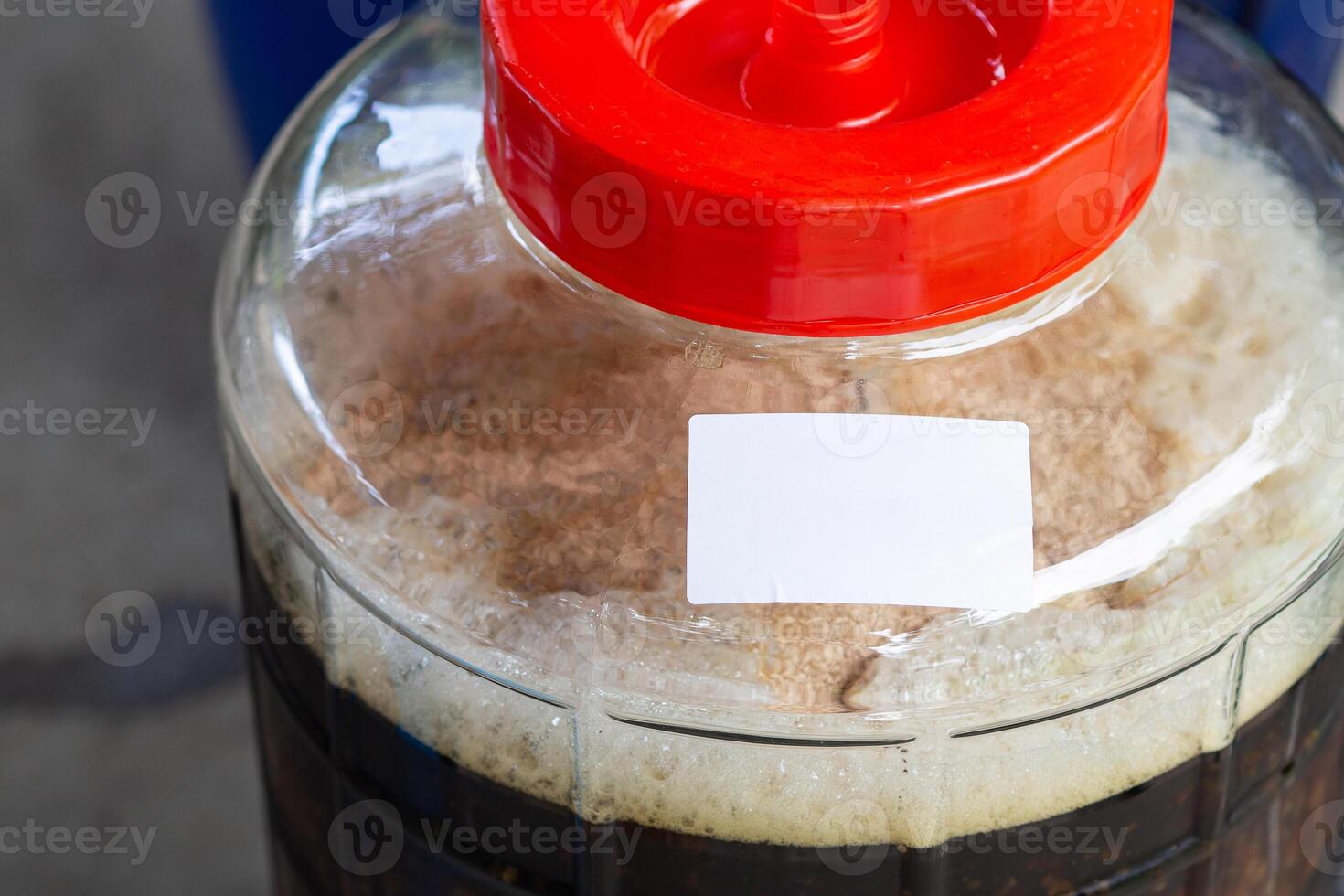 Close-up of craft beer and foam in a fermentation container. Process of making home beer from malt. Craft beer from barley and dark malt photo