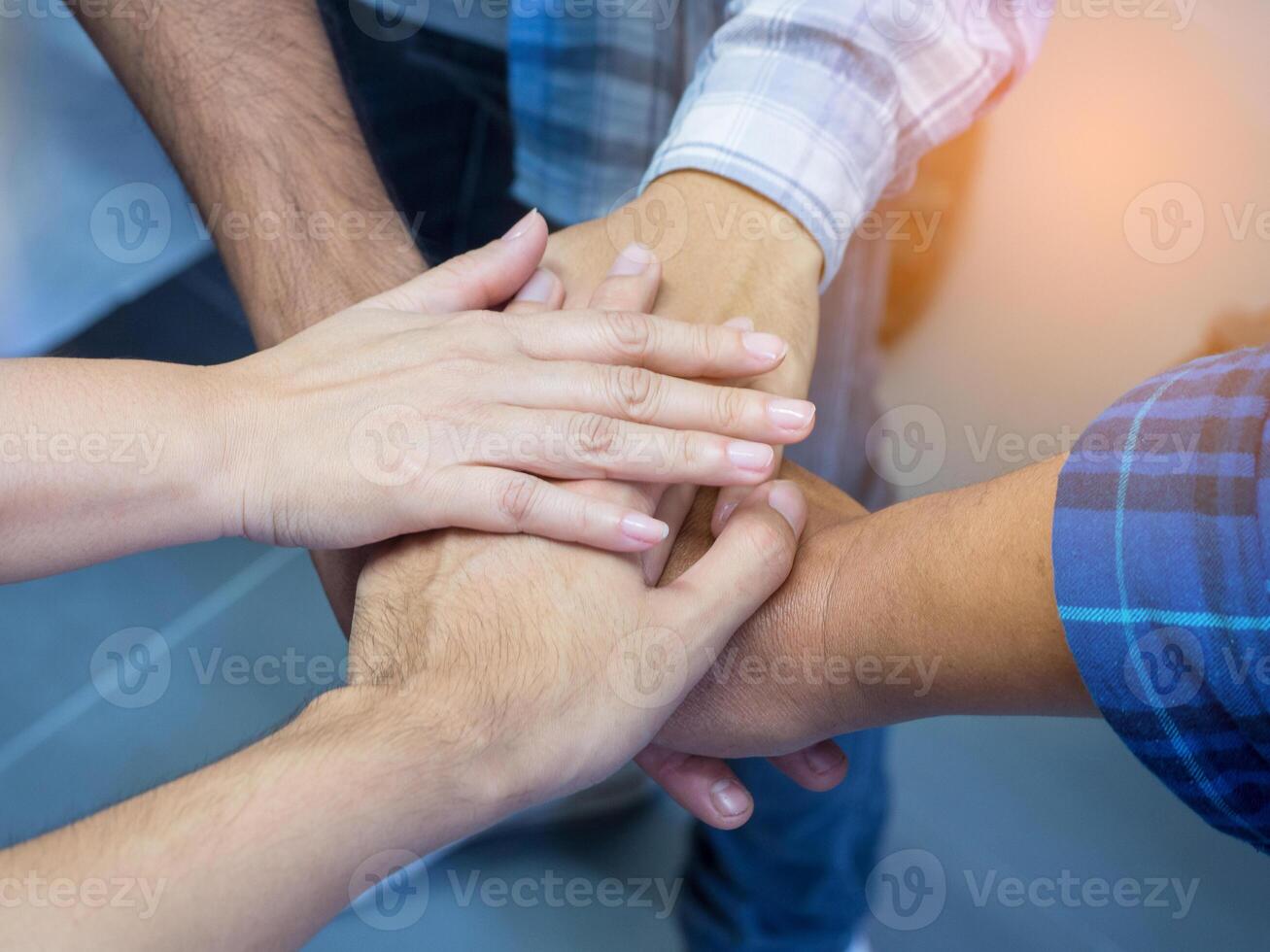 Close-up of many people hands in a circle together with sunlight effect. Concept of teamwork photo