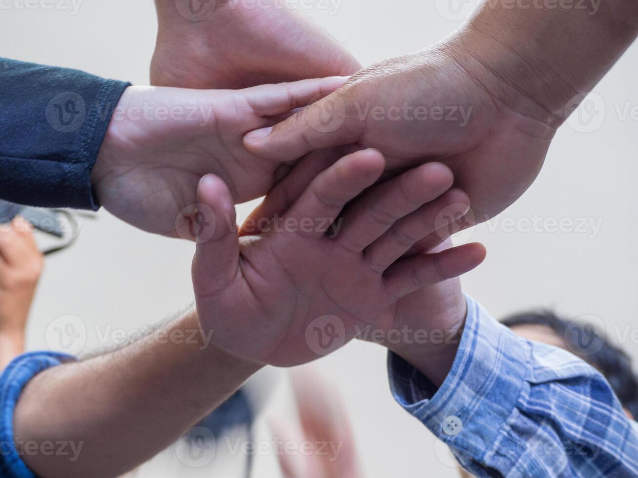 Many people hands in a circle together. Low angle of view. Concept of teamwork and unity photo