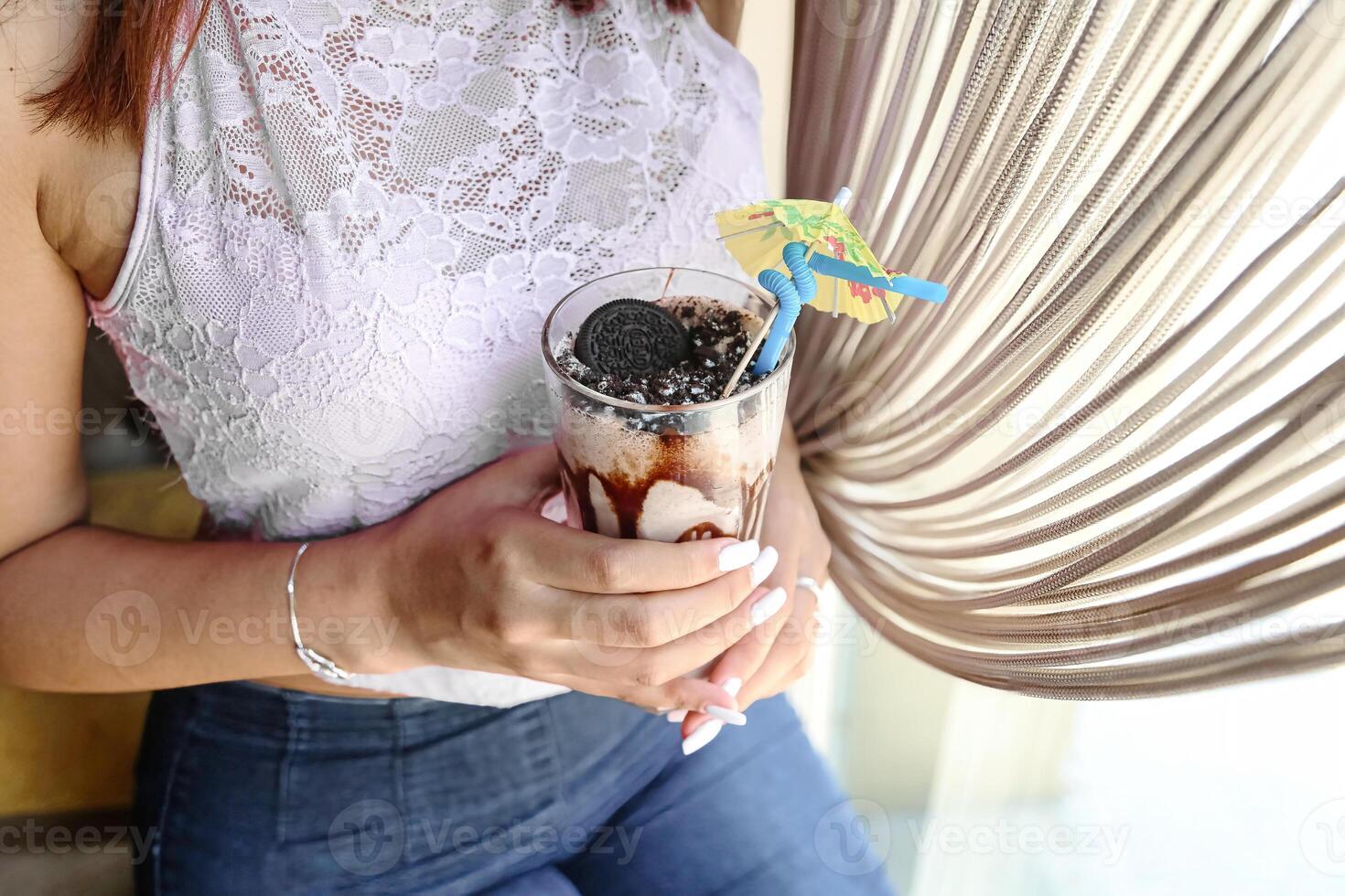 Woman Holding a Refreshing Drink at a Beach Cafe photo