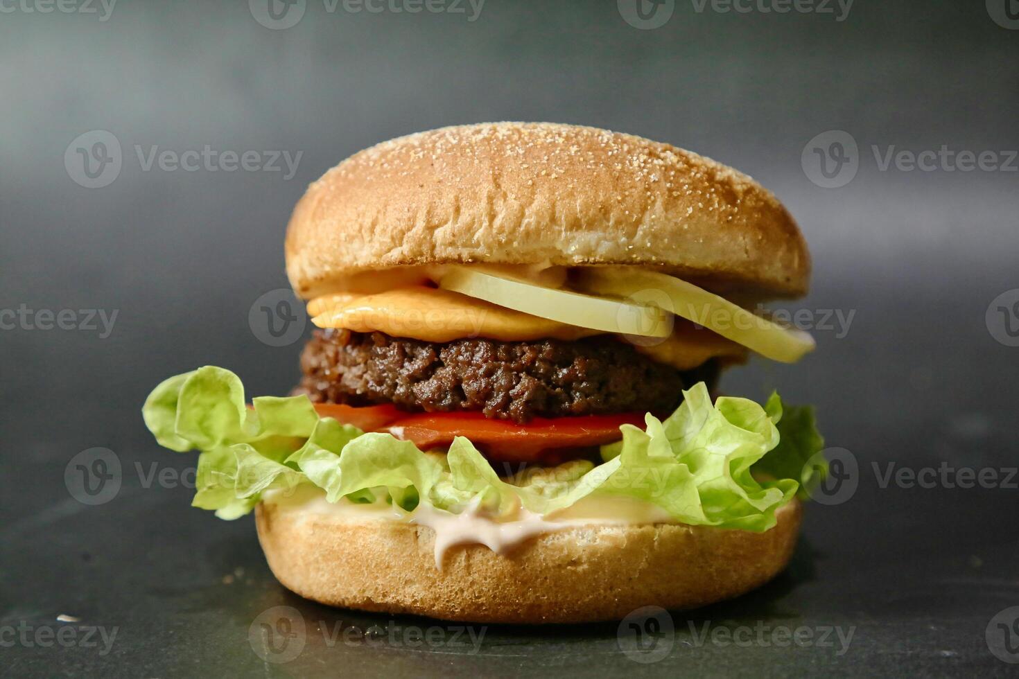 jugoso hamburguesa con lechuga y tomate en negro superficie foto