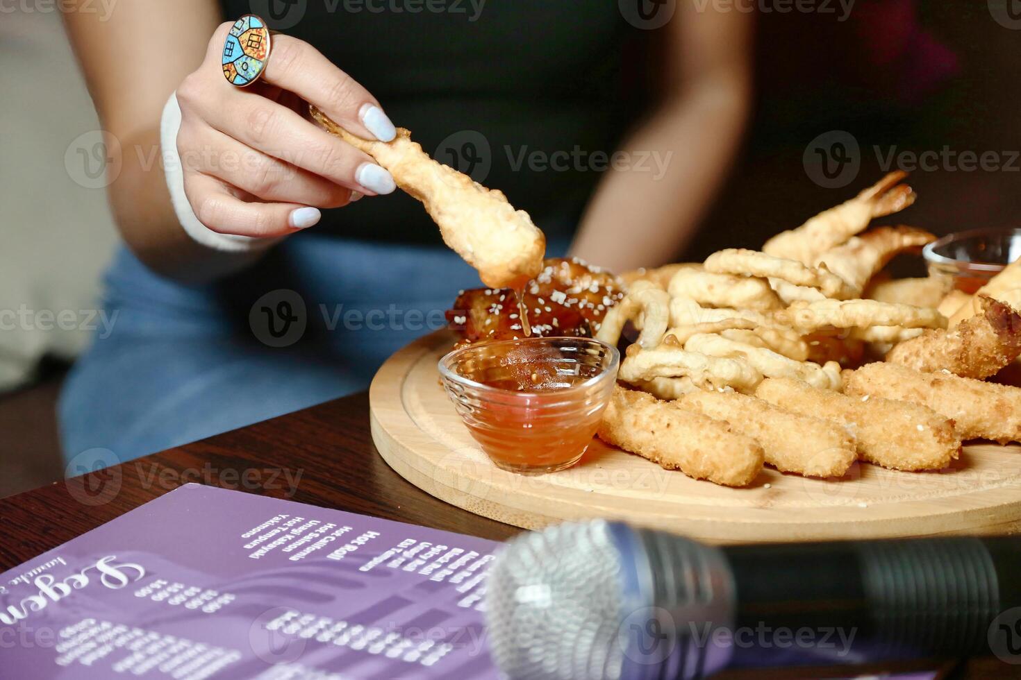 Person Dipping Sauce on Plate of Food photo