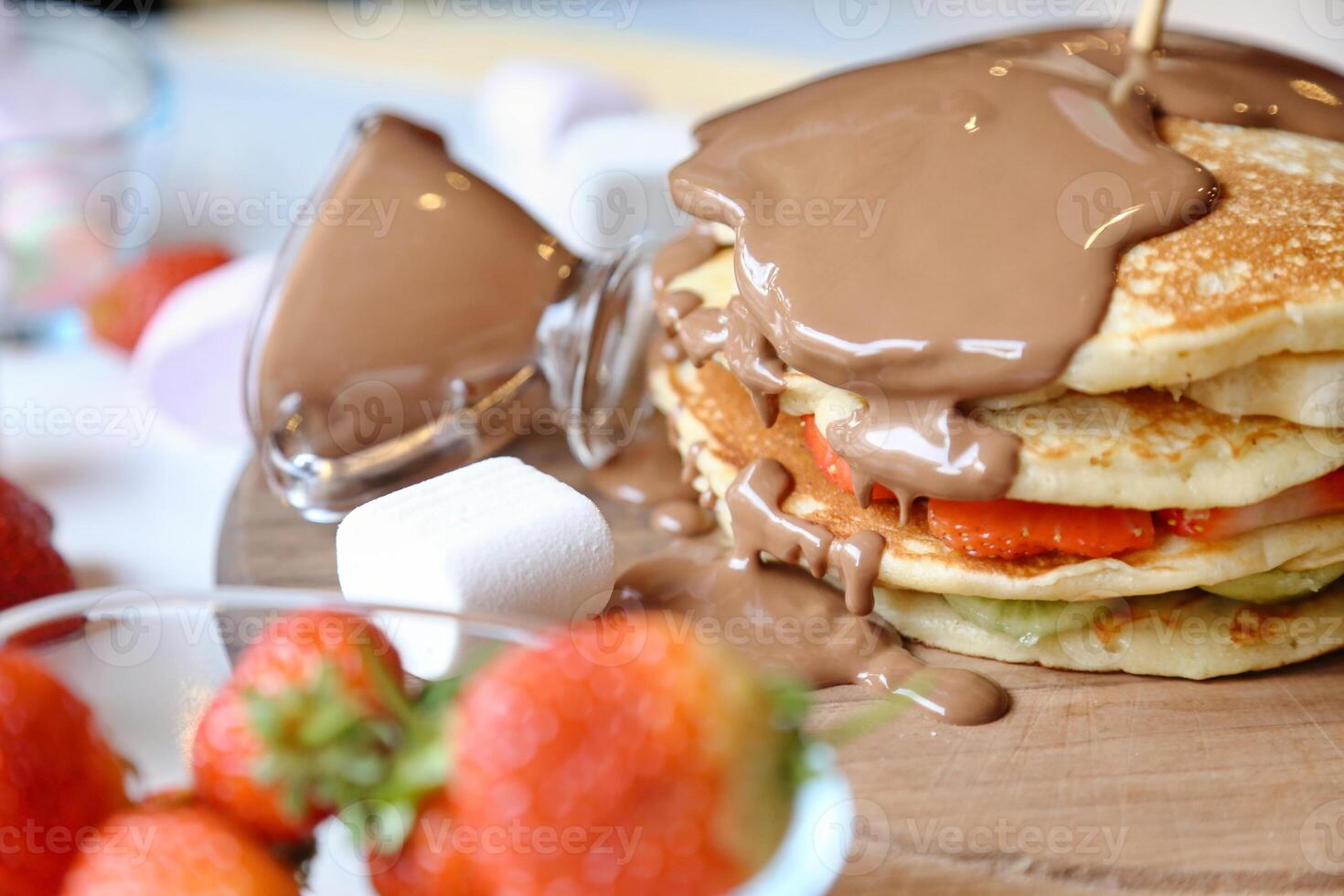 Stack of Pancakes With Chocolate Sauce and Strawberries photo